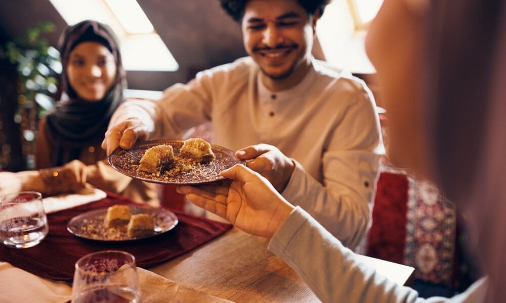 Feqah: Ilmu Hukum Syariah Islam Close-up of Islamic family eating baklava at dining table at home.
