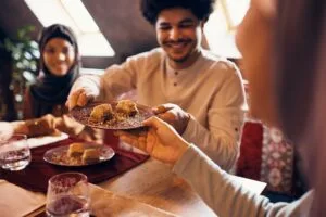Close-up of Islamic family eating baklava at dining table at home.