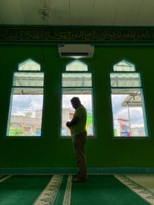 Muslim asian man praying performing salah at the mosque