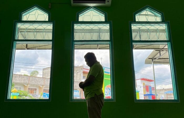 Muslim asian man praying performing salah at the mosque