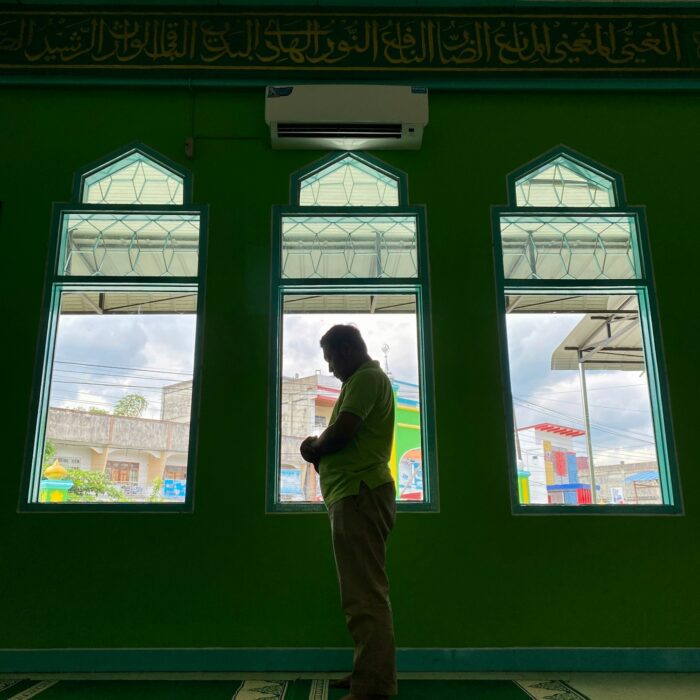 Muslim asian man praying performing salah at the mosque